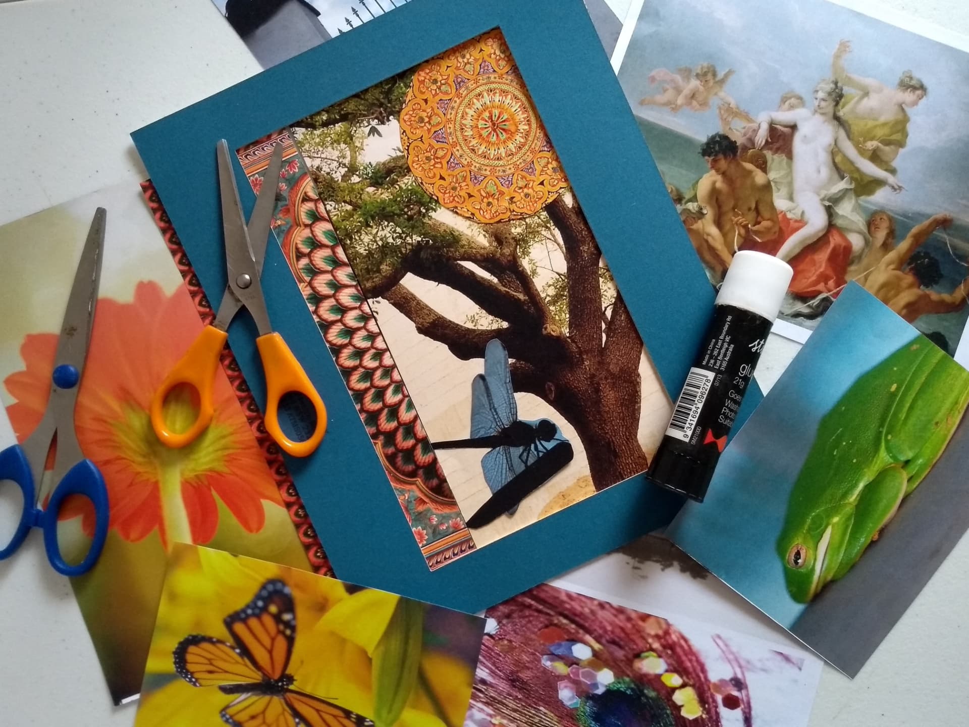 Tesouras, recortes de revistas e uma carta de colagem sobre a mesa